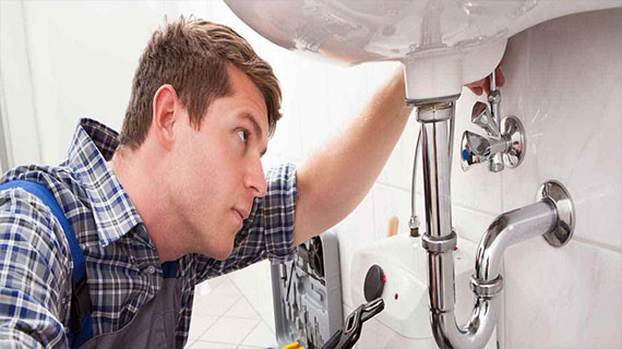 Local plumbing installation experts Technician providing professional plumbing and heating service at a residential property.